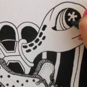 Close up of Artist drawing a turtle with a black Zig Posterman Waterproof Paint Marker
