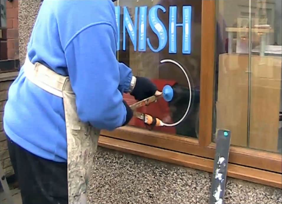 Removing Chalk Window Art, when done sign painter using a homemade compass to make a sign in a window. Circle is half done, with nice blue text above